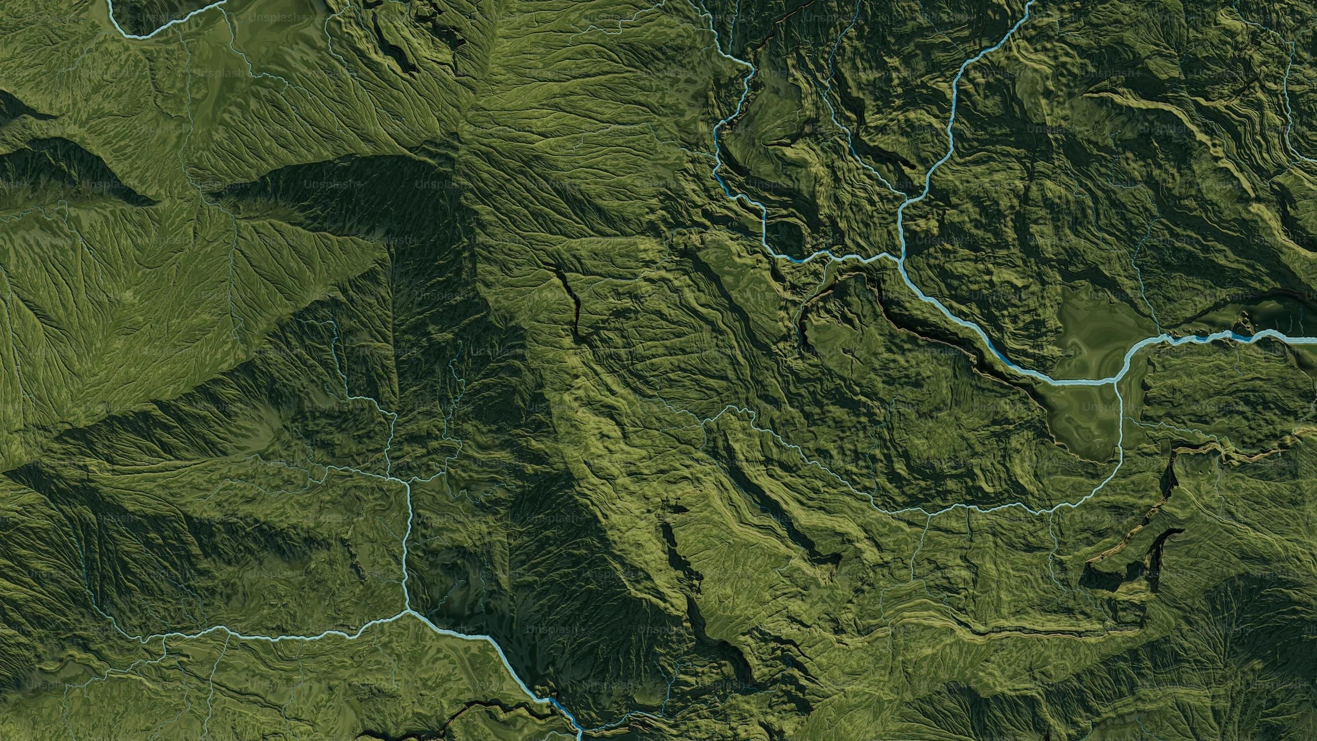 Aerial view of forested ridges cut by rivers