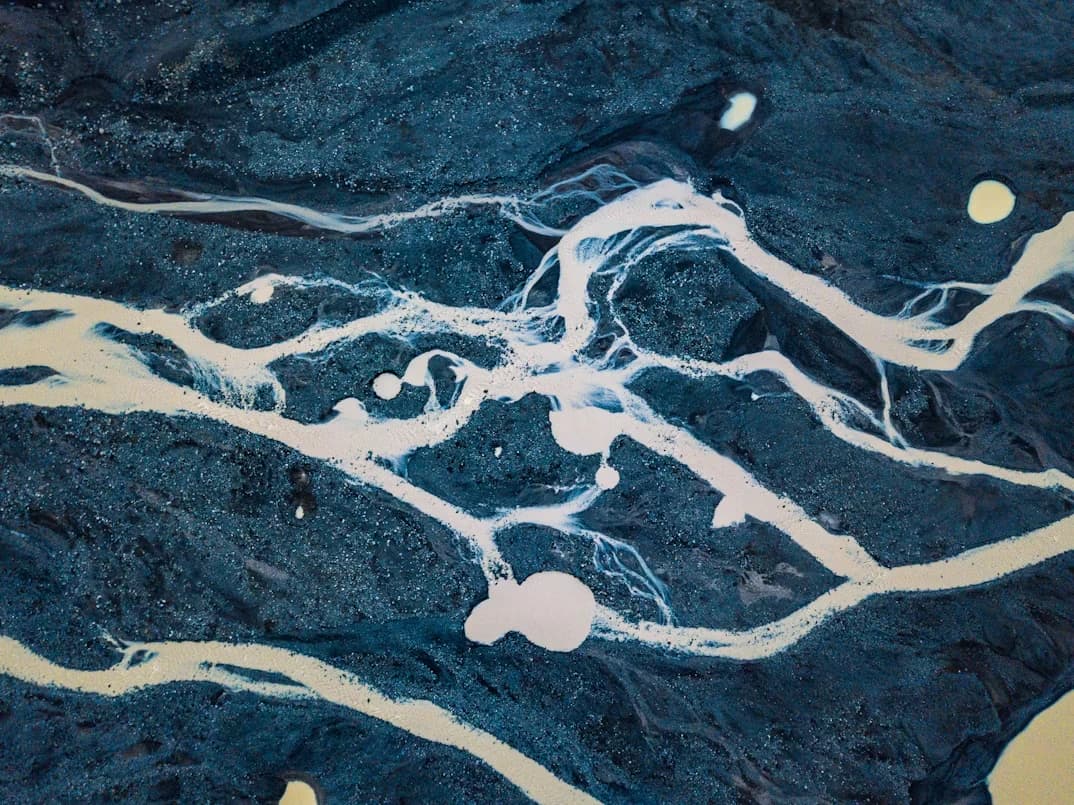 Glacial rivers carving through black sand
